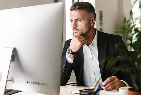 Image of confident businessman working in office and looking on computer