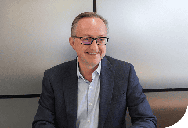 Professional businessman in suit smiling at RQC Group office, corporate leadership, business solutions, professional team, consultancy services, workplace success, business development, executive in work environment.